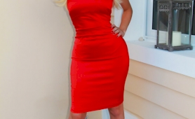 Sexy blonde tranny with a gigantic rack poses in a tight red dress